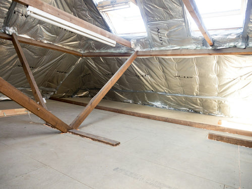 Insulated attic space with wooden beams and skylights